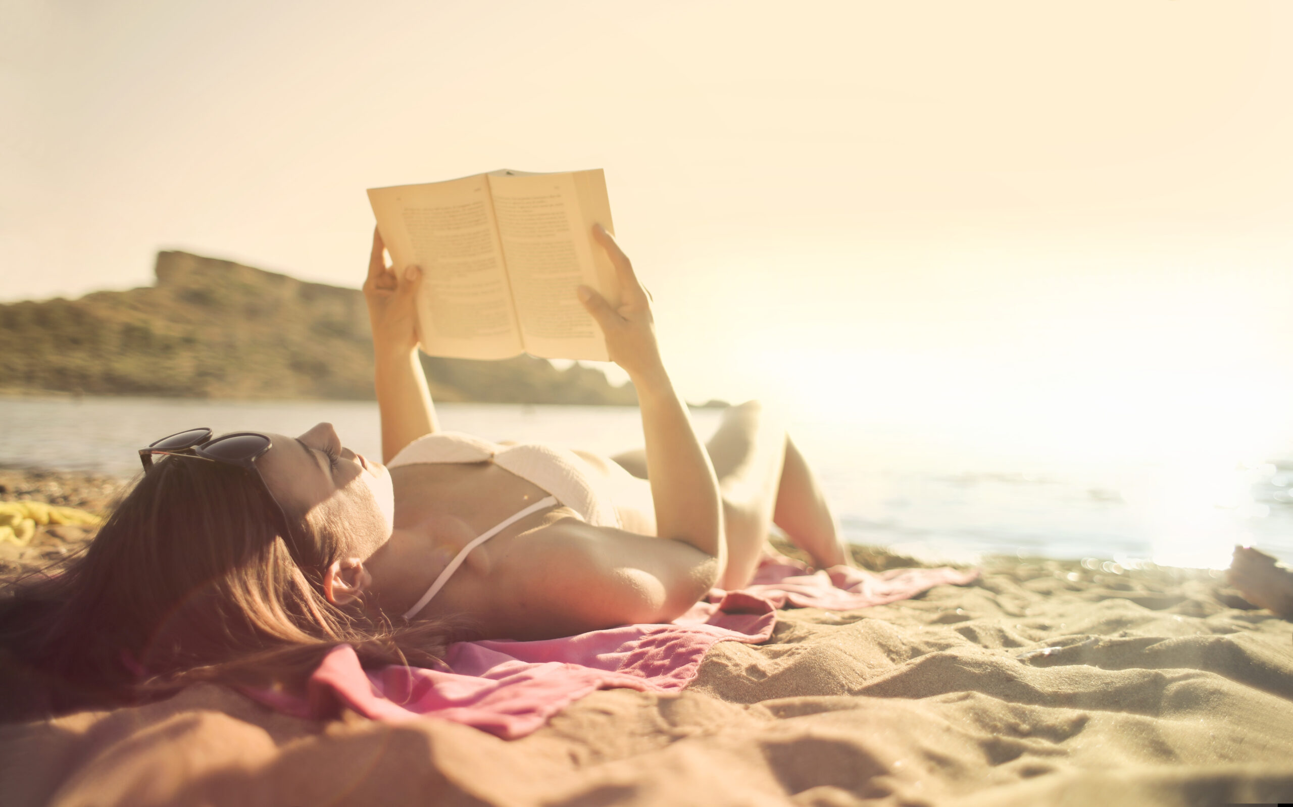 Frau am Strand mit Buch