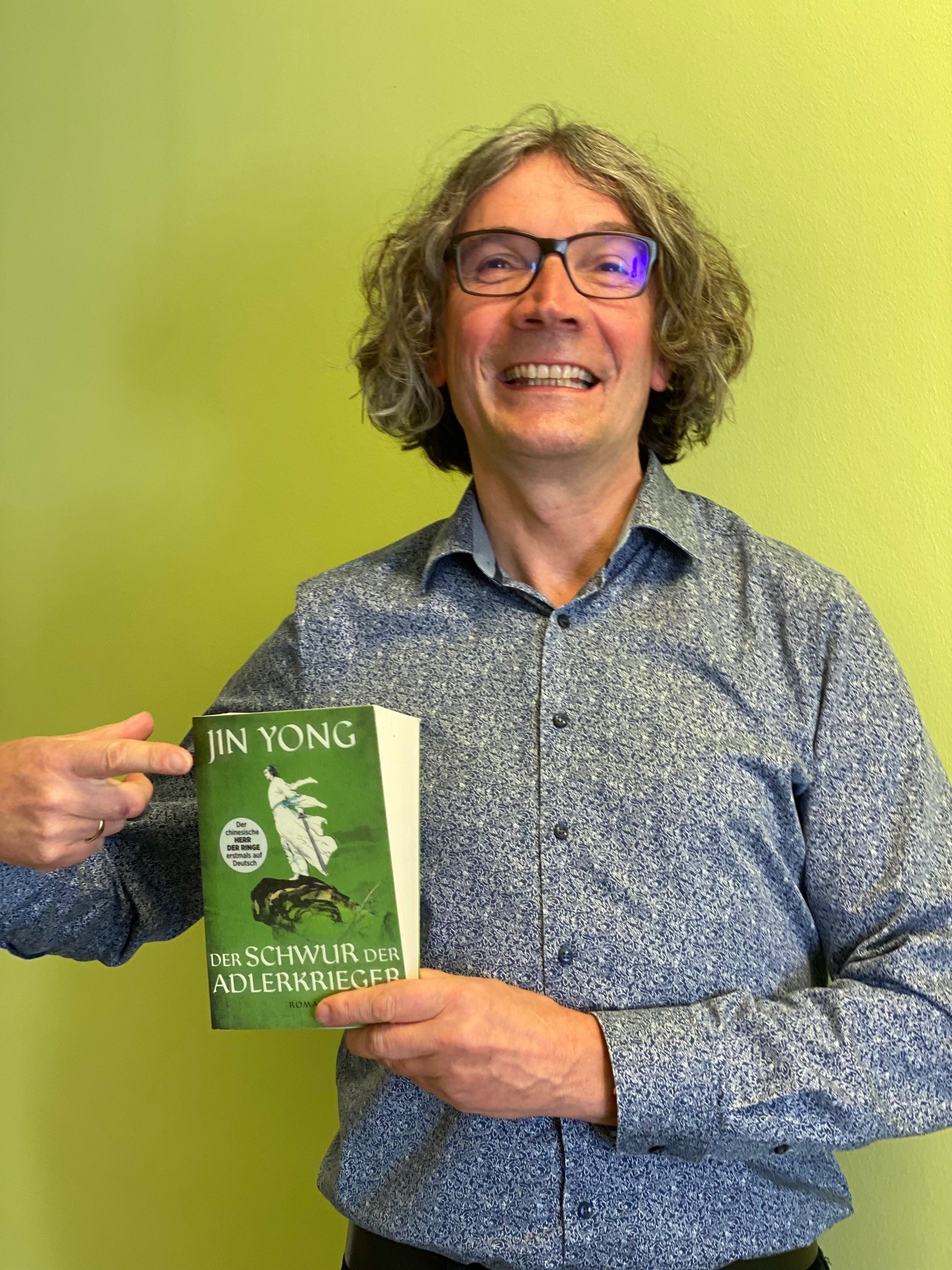 Mann mit Brille präsentiert ein Buch