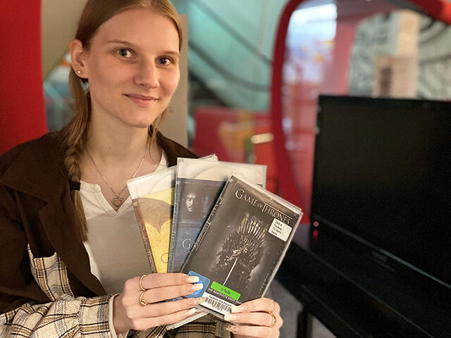 Junge Frau hält drei DVDs in den Händen