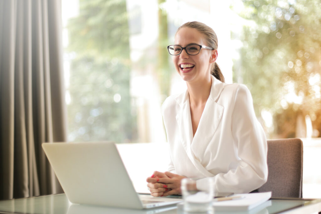 Junge Frau mit Brille an einem Laptop.