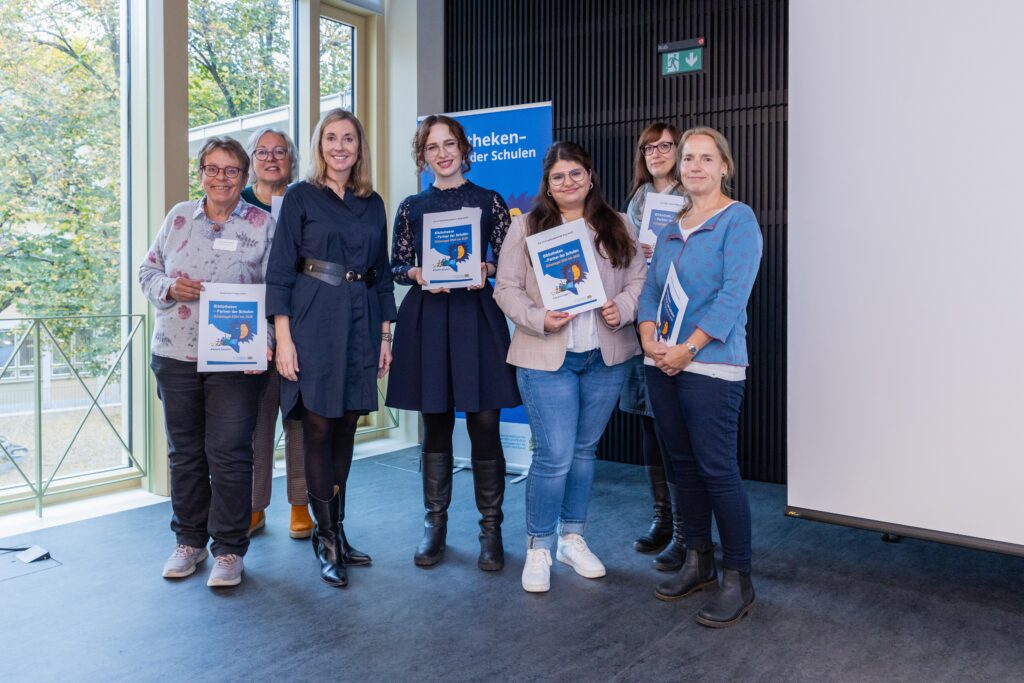 Gruppenfoto mit 7 Personen, die alle eine Urkunde in der Hand halten.