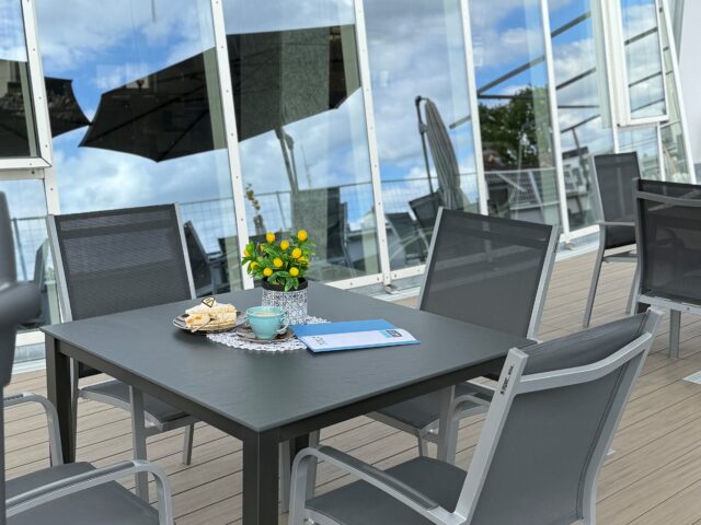 Ein Tisch auf einer Dachterrasse mit Kaffee und Kuchen.