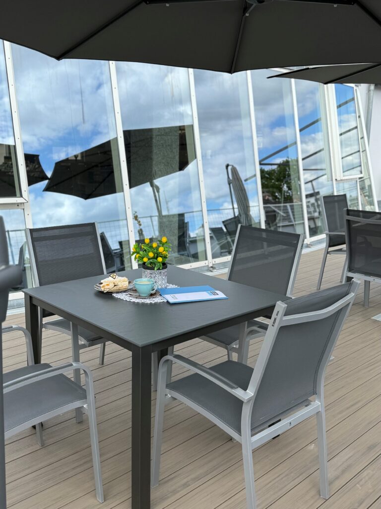 Ein Tisch auf einer Dachterrasse mit Kaffee und Kuchen.